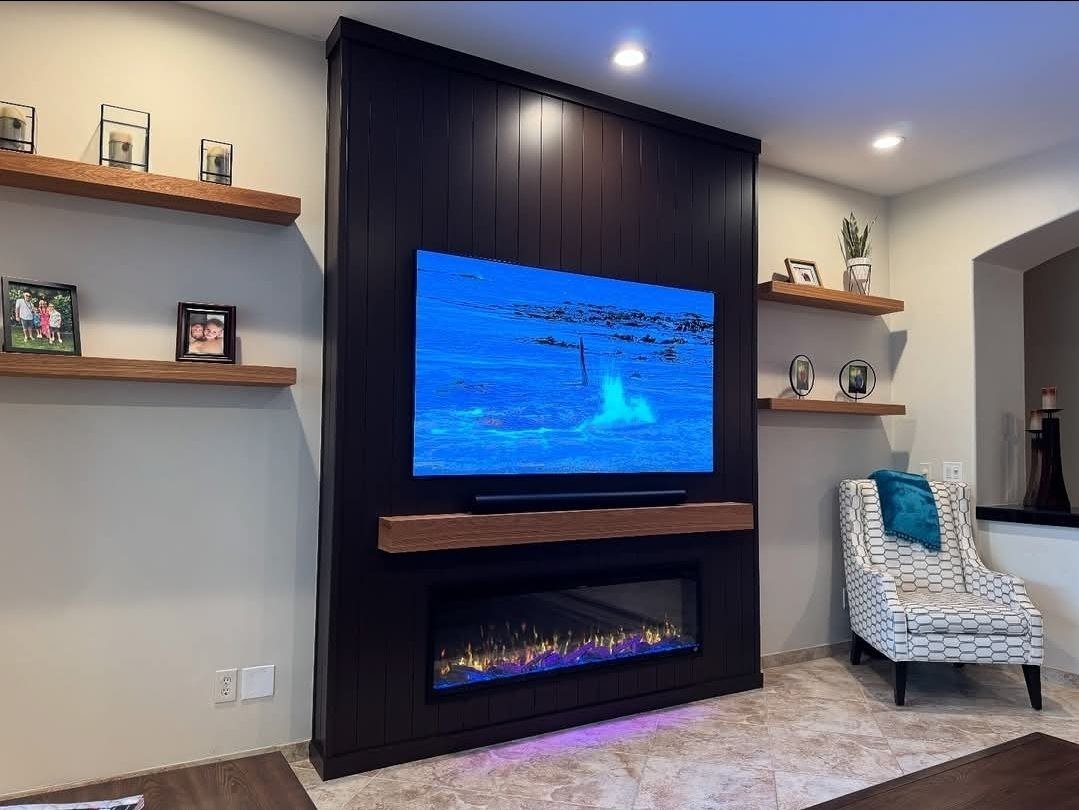 Dark vertical shiplap TV feature wall with electric fireplace in Charlotte, NC by Fast Fix Charlotte